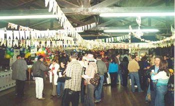 Salão enfeitado com bandeirinhas e cheio de gente em uma festa da ARH Serrana
